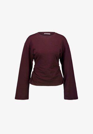 Langarm, dunkelviolettes Rundhalsshirt mit einem kleinen gestickten Logo auf der linken Brust vor einem weißen Hintergrund.