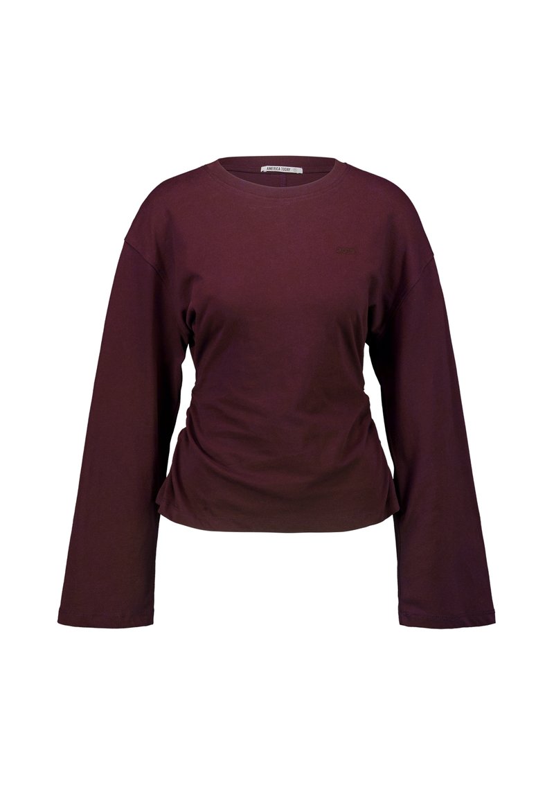 Camiseta de cuello redondo de manga larga en color púrpura oscuro con un pequeño logo bordado en el lado izquierdo del pecho sobre un fondo blanco.