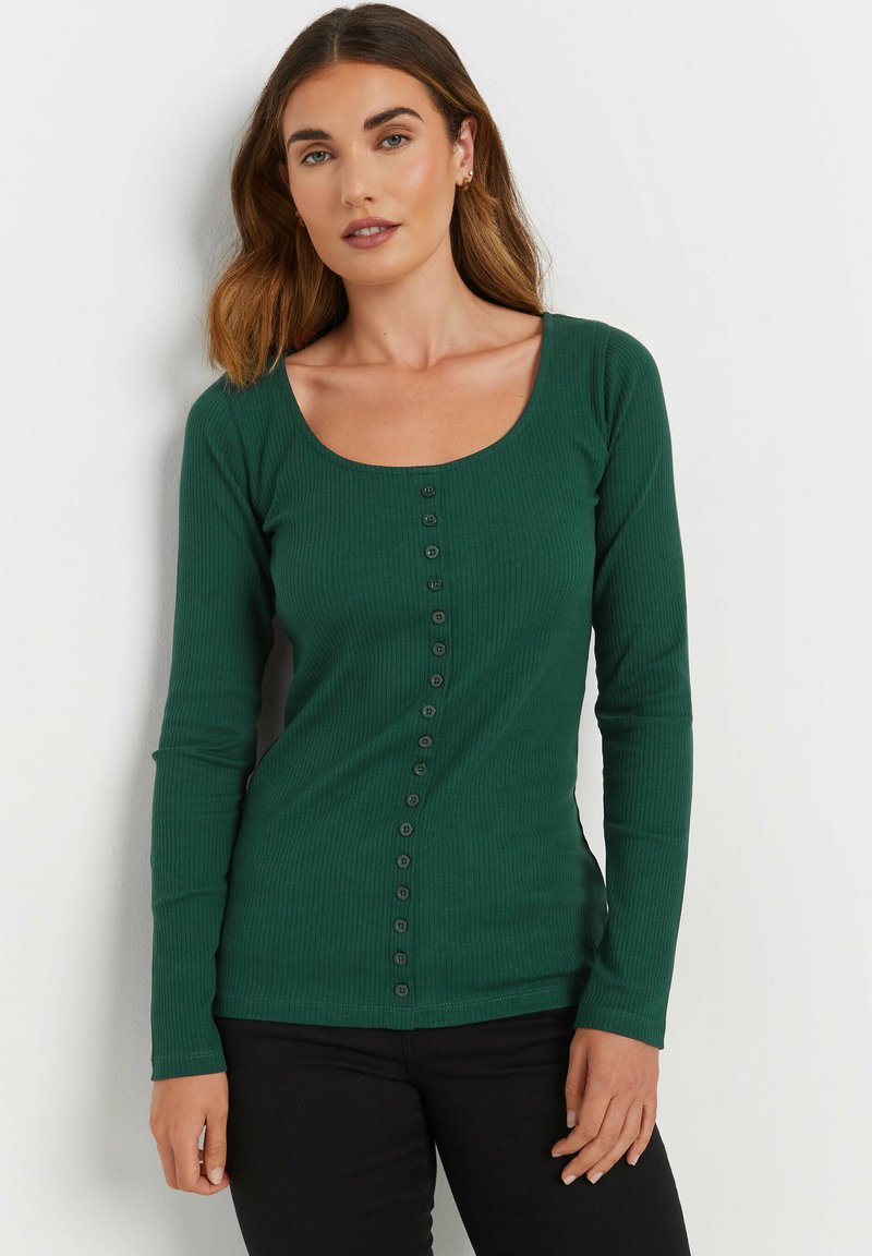 Tummanvihreä pitkähihaisen ribbineuleen paita, jossa on avara kaula-aukko ja etupuolella pystysuora nappilista. Pinta on sileä.