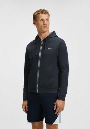Mörkblå zip-up hoodie med huva, ljusgrå dragkedja och framfickor. Har "BOSS"-logotypen på vänster bröstområde. Slät textur.