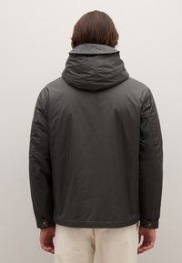 Giacca grigio scuro con cappuccio, caratterizzata da una texture liscia, polsini con bottoni a pressione e una vestibilità comoda. Design semplice, senza motivi visibili.