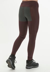 Des leggings de sport bordeaux dotés d'un panneau texturé gris à l'arrière. Design taille haute avec des coutures contrastées. Assortis à des chaussures de training noires.