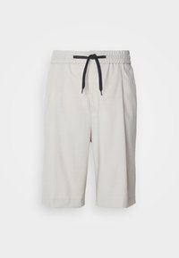Pantaloni shorts beige chiaro con cintura elastica e cordino nero. Presentano tasche laterali e una vestibilità comoda, il tessuto ha una trama sottile.
