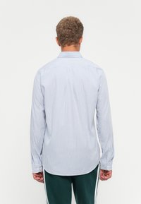 Blau-weißer gestreifter Langarmshirt mit Button-Down-Kragen und Manschettenknöpfen, ausgestattet mit einem geraden Rückendesign und leichtem Stoff.
