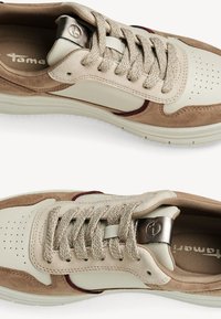 Beige och beige sneakers i mocka och lädermaterial, med perforeringar, metalliska detaljer och vävda snören i en strukturerad finish.