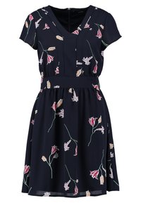 Lyhythihainen tummansininen mekko V-pääntiellä, jossa on vaaleanpunaisia ja beigefloraalikuvioita, vyötärö on istuva ja hame levenee.