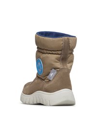 Botte d'hiver marron avec tige rembourrée, doublure intérieure bleue, logo rond bleu et semelle en caoutchouc texturé blanche, inclinée pour montrer les détails arrière et latéraux.