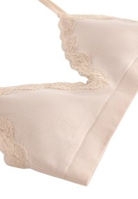 Bralette beige chiaro con texture a coste, bordo in pizzo lungo il collo e spalline regolabili. Materiale morbido, design senza cuciture, senza ferretto.