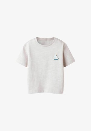 Camiseta de algodón gris claro con cuello redondo, mangas cortas y un pequeño bordado de velero azul en el lado izquierdo del pecho. Textura suave.