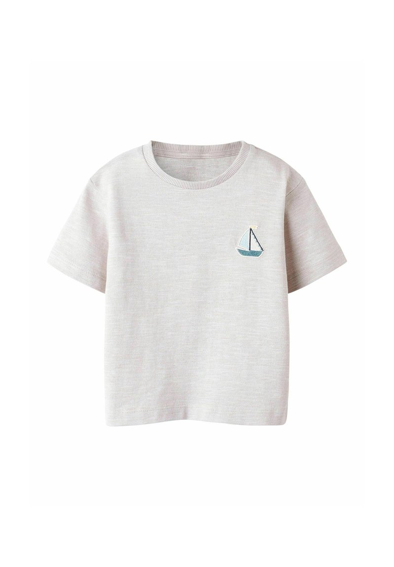 Camiseta de algodón gris claro con cuello redondo, mangas cortas y un pequeño bordado de velero azul en el lado izquierdo del pecho. Textura suave.