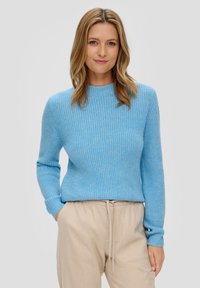 Helles blaues, geripptes Strickoberteil mit rundem Ausschnitt und langen Ärmeln, kombiniert mit beigen Hose mit Zugband. Weicher Stoff mit eng anliegenden Bündchen.