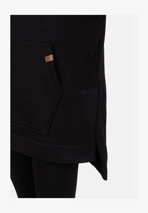 Sort sweatshirt med en kængurulomme, tekstureret stof og et lille brunt lædermærke på siden, med en let forlænget kant.