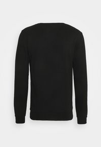 Svart långärmad sweatshirt med ribbad mudd och fåll, visad från baksidan mot en enkel vit bakgrund.