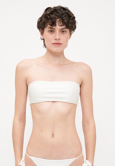 White bandeau bikini top with smooth texture and minimalist design. Elastic band for secure fit, paired with contrasting bikini bottom.