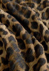 Leopardenmusterstoff mit einer strukturierten Oberfläche und braunen sowie schwarzen Mustern. Das Material wirkt weich und leicht zerknittert.
