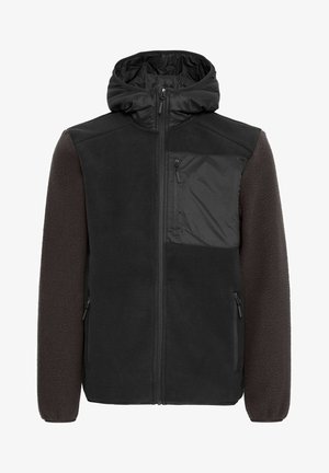 Kapuutšiga lukuga jope, millel on must fliis ja tumepruunid tekstureeritud varrukad, lukuga rinnatasku ja kaks küljetaskut.