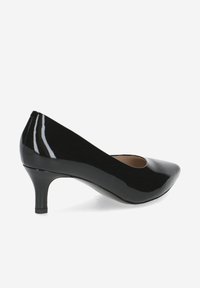 Pompe à talons hauts en cuir verni noir avec un bout pointu et un petit talon aiguille. Texture lisse avec une finition brillante.