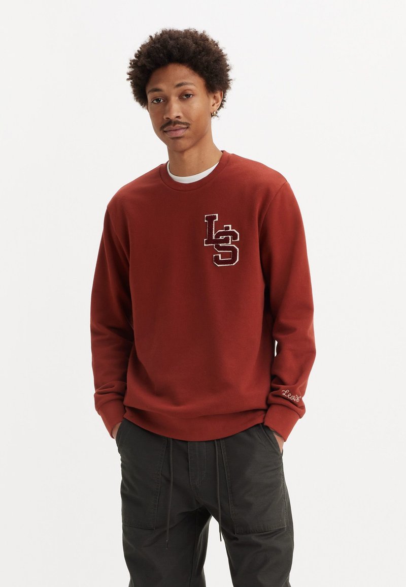 Bordeaux sweatshirt met een ronde hals en witte afwerking, voorzien van een geborduurd "LS" logo op de borst en merkdetail op de mouw.