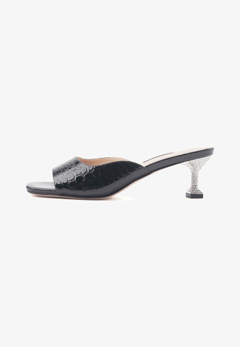 Black open-toe mules with a glossy finish, featuring a unique textured pattern and a sparkling crystal-embellished block heel.
