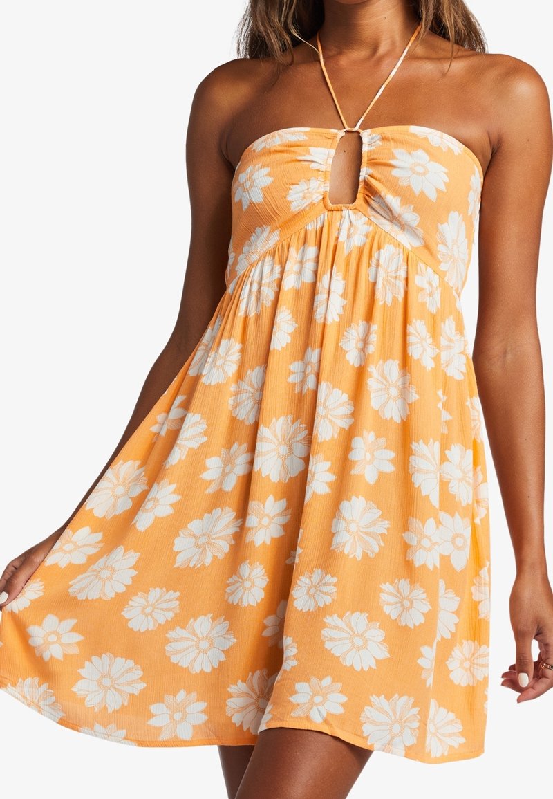 Stropeløs sommerkjole i orange med hvid blomsterprint, med en nøglehulldetail og sammensnøring, lavet af et let, struktureret materiale.