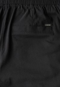 Svartrutiga shorts i tyg med elastisk midja, ett bakfack och en liten metallgalet "Cecil"-logotyp som accent. Slät struktur, avslappnad design.
