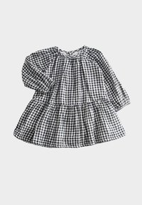 Czarna i biała sukienka w kratkę o długich rękawach, okrągłym dekolcie i warstwowej spódnicy. Wykonana z lekkiego materiału o teksturowanym wykończeniu.