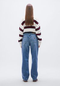 Μπλε τζιν παντελόνι με φαρδιά πόδια από τζιν ύφασμα με ανοιχτό πλύσιμο, που διαθέτει αντίθετη ταμπέλα σε ταμπά χρώμα και μικρό λογότυπο στην πίσω τσέπη.