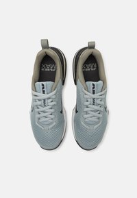 Light blue athletic shoes with mesh upper, gray accents, white sole, and black logo. Features round laces and a pull tab on the heel.