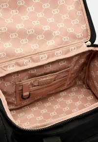 L'interno della borsa nera presenta una fodera in tessuto rosa chiaro con un motivo a logo ripetuto. Include una tasca in rete e un'etichetta frontale.