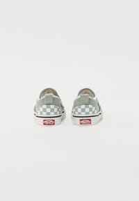 Grau-weiße kariert Canvas-Slipper mit flacher weißer Sohle und rotem Logoakzent. Rückansicht, die die doppelte Stoffstruktur präsentiert.
