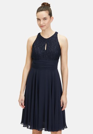 Robe bleu marine avec un corsage en dentelle ajusté, découpe en forme de trou de serrure et jupe évasée. Design sans manches avec une texture lisse et fluide.