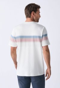 T-shirt en coton blanc pour homme avec des rayures horizontales en rose clair, bleu et bleu foncé dans le haut du dos. Manches courtes, coupe décontractée.