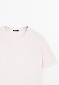 Light pink short-sleeve t-shirt made from smooth cotton. Features a round neckline and subtle stitching details. Brand label visible inside.