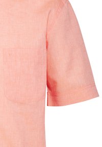 Camicia a maniche corte in morbido lino rosa chiaro con taschino sul petto e una sottile texture, caratterizzata da un taglio pulito e da dettagli di cucitura decorativa.