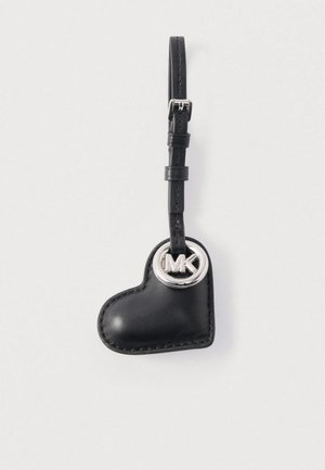 Black leather heart-shaped keychain with silver MK logo, featuring contrasting stitching and a textured finish. Attachable strap included.