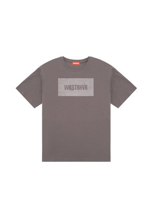 T-shirt gris à manches courtes avec une impression rectangulaire sur la poitrine portant la mention WRSTBHVR et une petite étiquette rouge WRSTBHVR à l’intérieur du col.