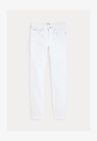 Białe obcisłe jeansy z pięcioma kieszeniami, szlufkami na pasek i zapięciem na guzik, ułożone płasko na jasnym tle.