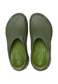 Zielone buty wsuwane z gładką, fakturowaną powierzchnią i falistym wzorem. Wewnątrz znajduje się pasująca zielona wkładka z logo marki.