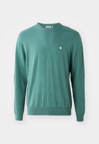Green knitted sweater with long sleeves, round neck, and ribbed cuffs. Features a small white logo on the chest. Smooth texture.