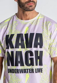 Svetlo fialové tričko s krátkymi rukávmi s čiernym textom "KAVA NAGH" a "UNDERWATER LOVE", s neonovo zelenými vzormi podobnými koralovým celým povrchom.