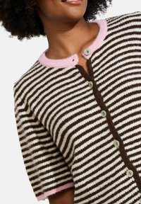 Brūns un krēmkrāsas svītrainais kardigans ar īsām piedurknēm, ar rozā ribotu apkakli un priekšējiem pogām, izgatavots no mīksta vilnas maisījuma.