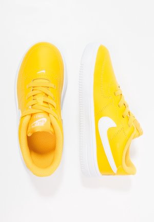 Gule Nike-sneakers med en glat syntetisk overdel, hvide accenter og snørebånd. Har en tekstureret indersål og en hvid gummiydersål.