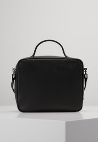 Schwarze Ledertasche mit strukturiertem Finish, quadratischer Form, oberem Griff und verstellbarem Tragegurt. Mit silbernen Hardware-Akzenten.