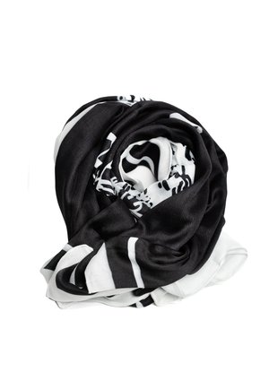 Sorte og hvide tørklæde, lavet af blødt stof, har et virvlende design med markant kontrast og glat tekstur. Snoet i en spiralform.