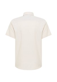 Koszulka z krótkim rękawem w jasnym beżowym kolorze, wykonana z teksturowanej tkaniny, z klasycznym kołnierzykiem i prostym dołem. Prosty wzór z tyłu.