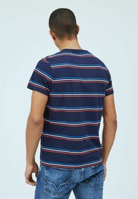 Camiseta de rayas marineras de manga corta, con rayas horizontales en azul claro, rojo y blanco, fabricada en tejido suave, combinada con jeans de mezclilla azul.