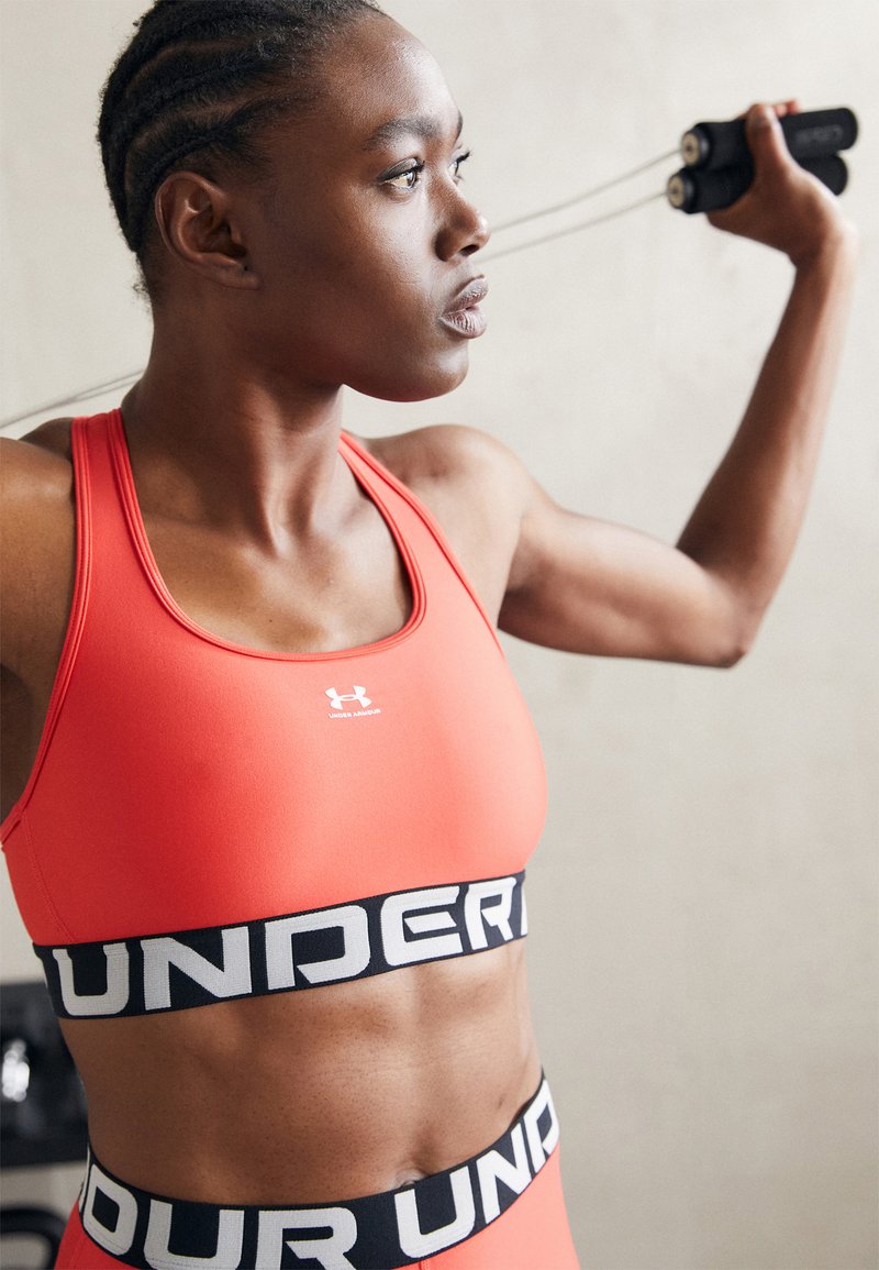 Under Armour MID BRANDED - Vidutiniškai krūtinę prilaikanti sportinė liemenėlė - red solstice/white
