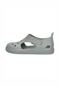 Sandalias infantiles grises hechas de goma flexible. Las características del diseño incluyen agujeros para ventilación, una correa de Velcro y suelas texturizadas para mayor agarre.