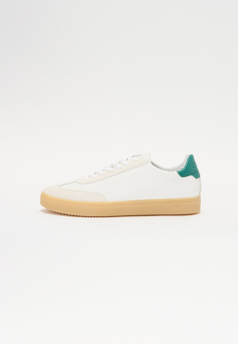 White sneaker with beige rubber sole, teal accent on heel, smooth leather upper, and flat white laces. Minimalistic design.