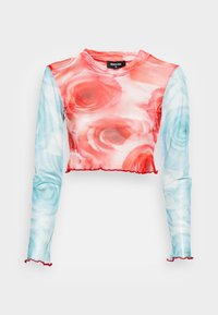 Top cropped de manga longa com um padrão floral em tons de vermelho e azul, com barra e punhos em babados. Feito de tecido leve e elástico.